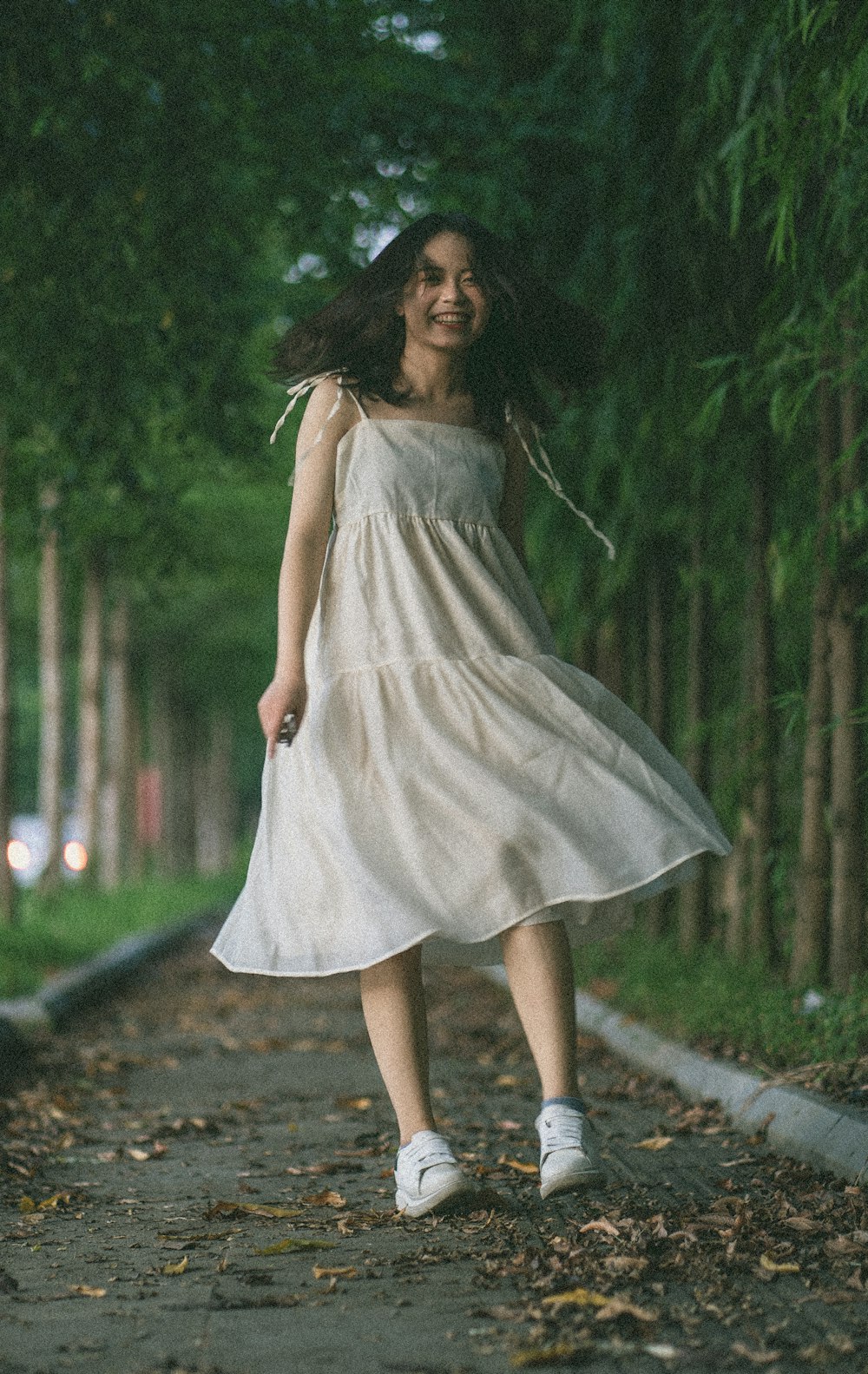 mujer con vestido blanco sin mangas de pie en el camino