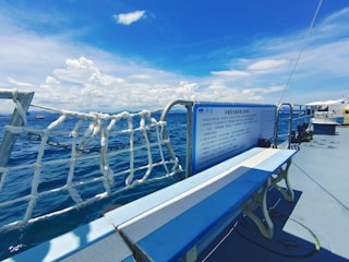 Instructor guiding a group of trainees on yacht safety procedures on a sunny deck.