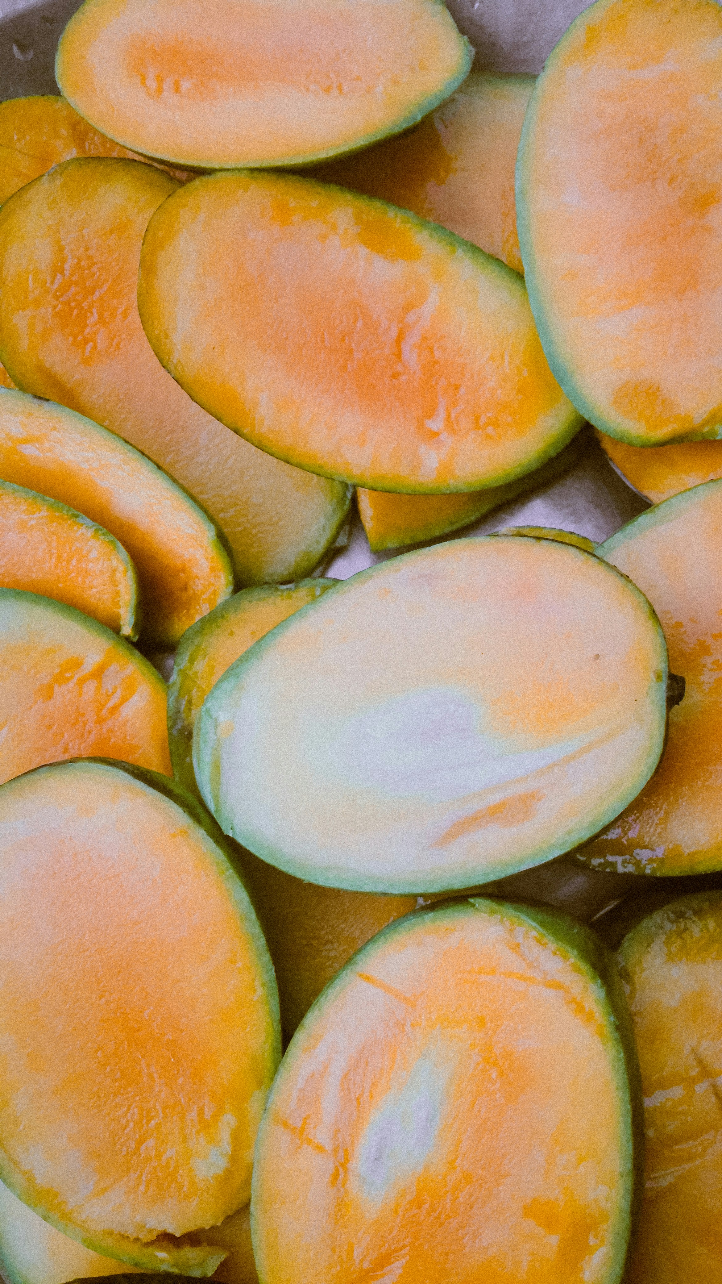 Sliced fresh mango pieces arranged on a flat surface.