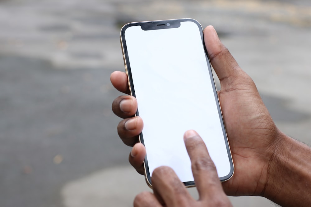 Persona sosteniendo un iPhone 6 plateado con funda negra