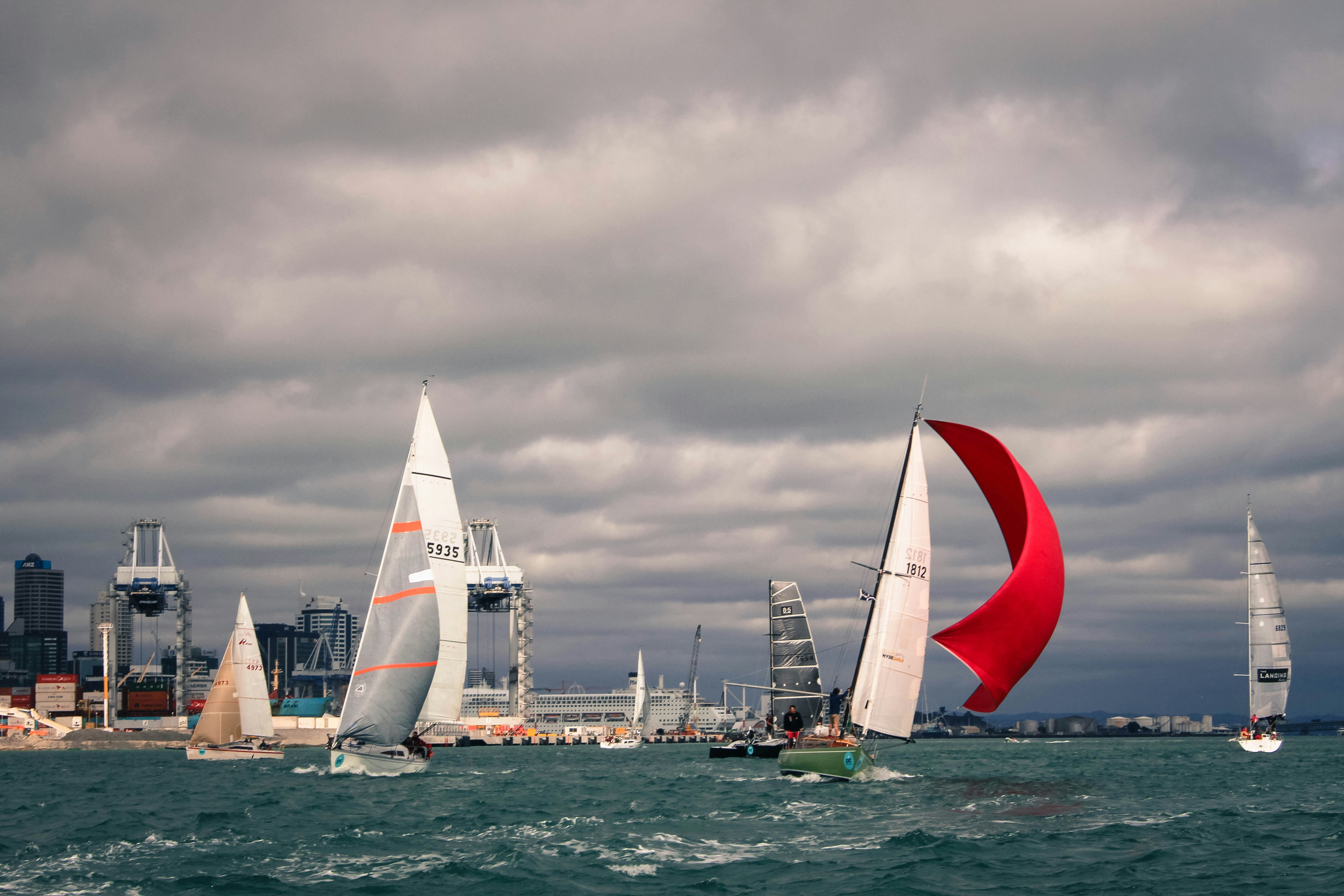white sail boat on sea under cloudy sky during daytime