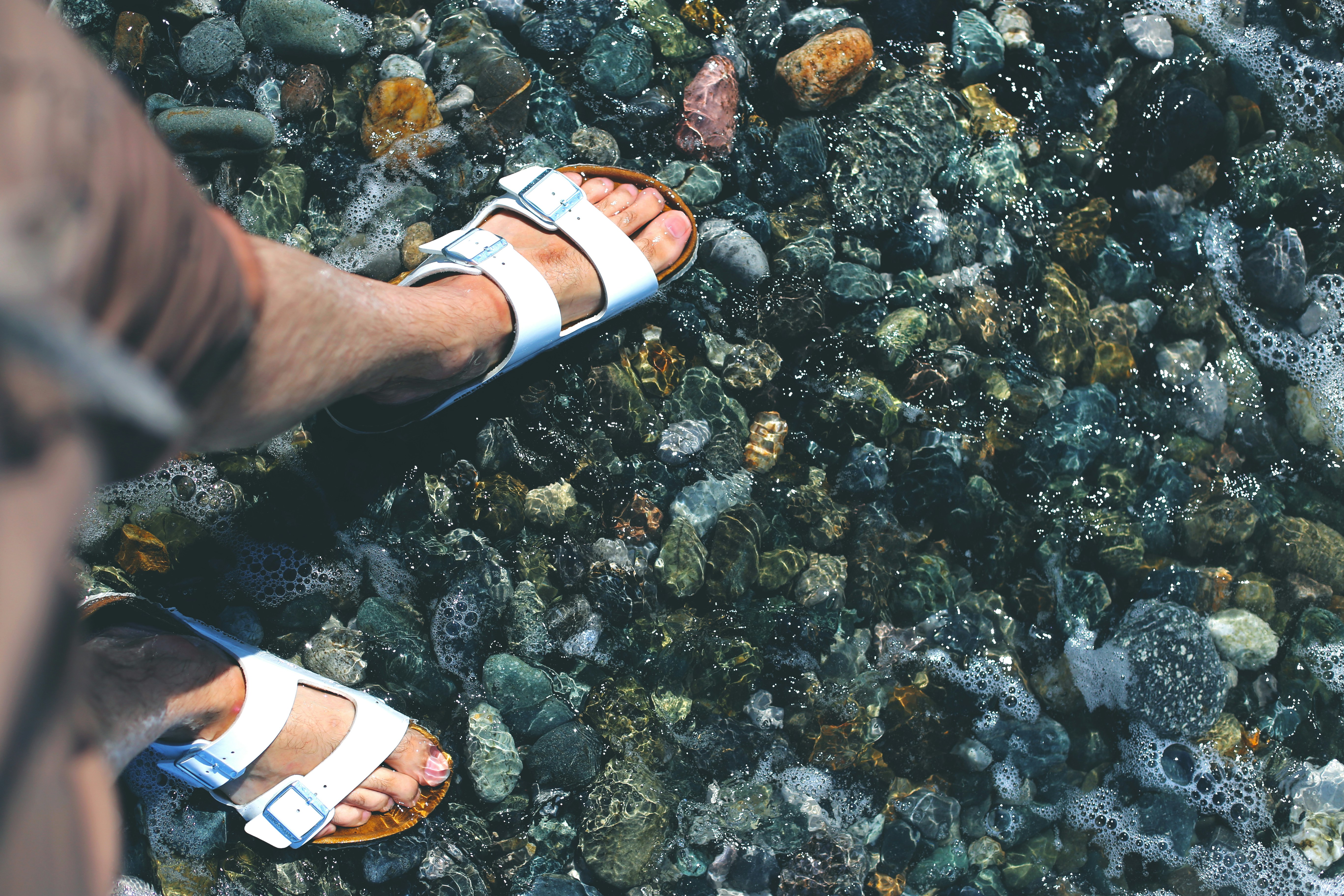 person wearing white and black leather sandals