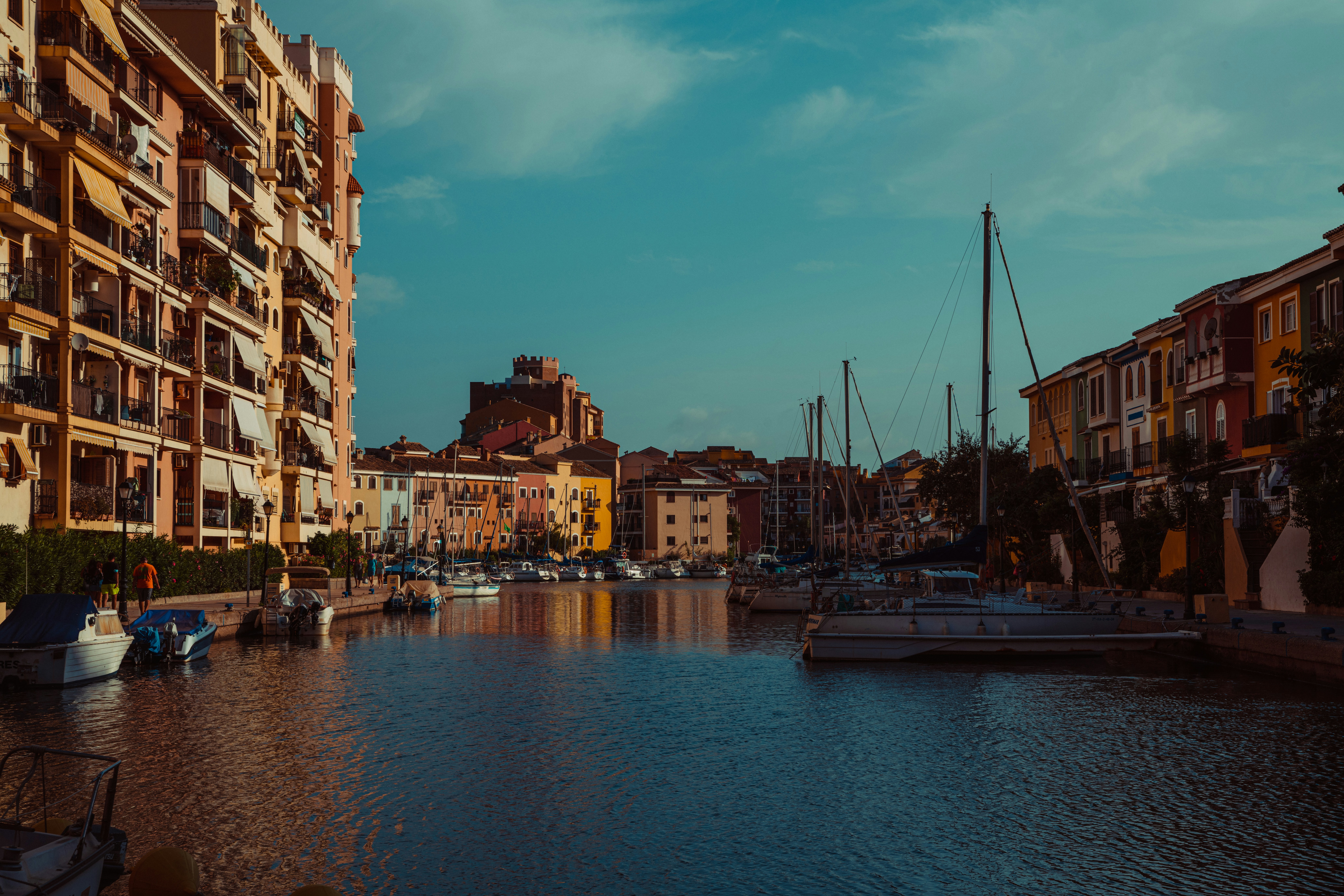 white and blue boat on water near city buildings during daytime