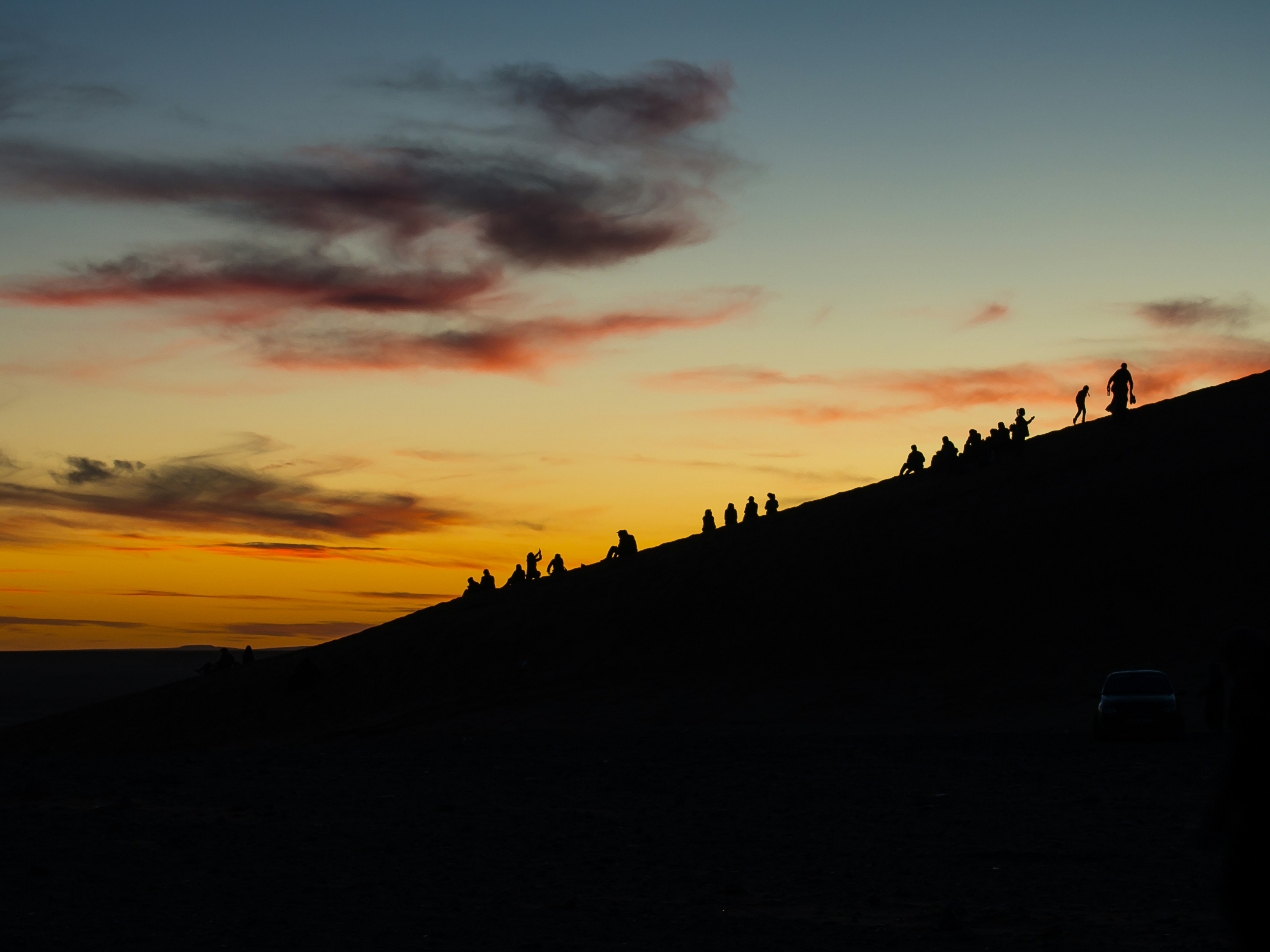 silhouette of people on hill during sunset