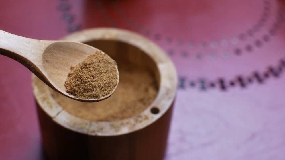 brown wooden round container on pink textile