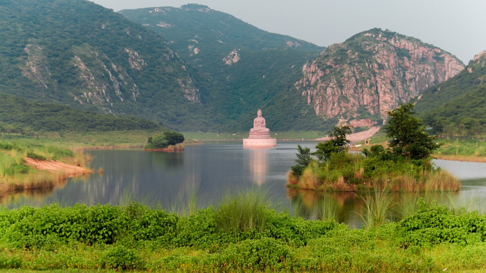 body of water near green mountain during daytime