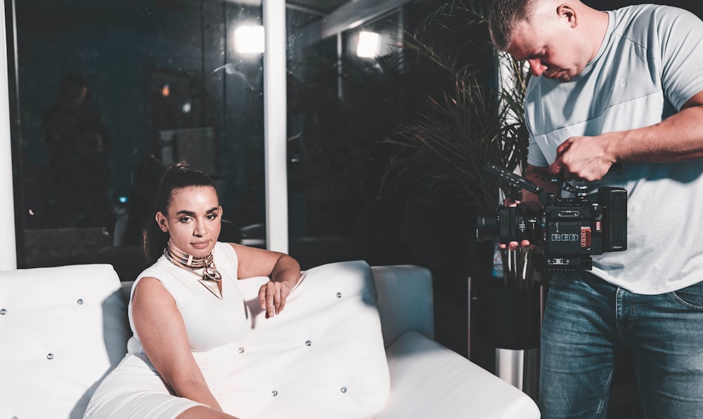 man in white tank top sitting on white couch