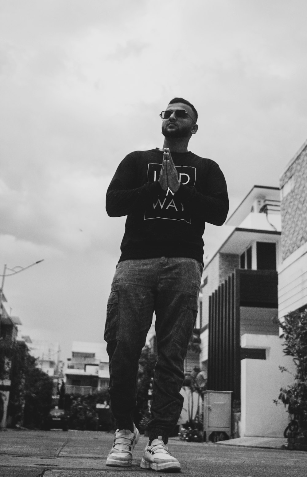 man in black hoodie and blue denim jeans standing on the ground