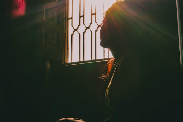 窓辺に座り穏やかに考える女性