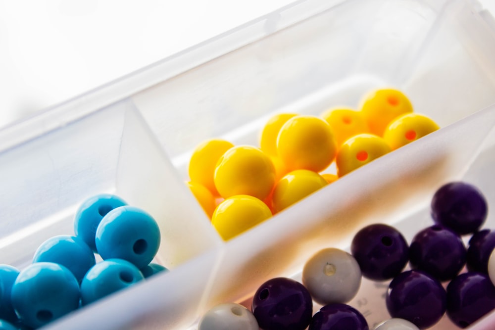 yellow blue and black beads on white plastic container