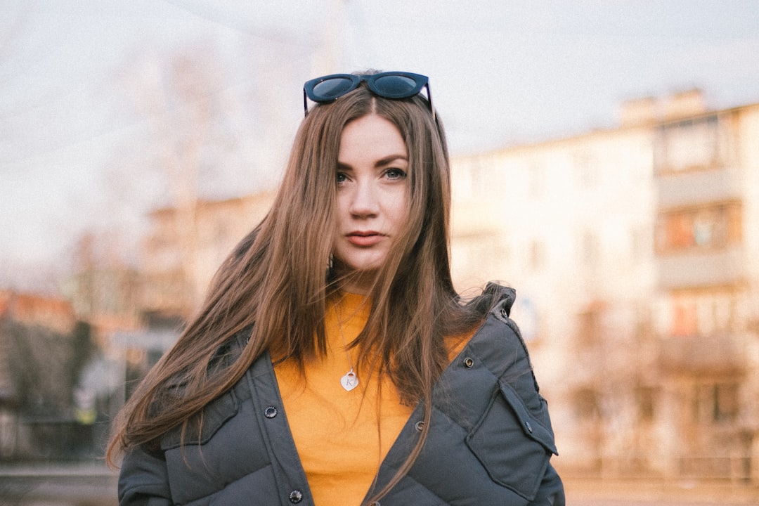 woman in black jacket and blue framed sunglasses