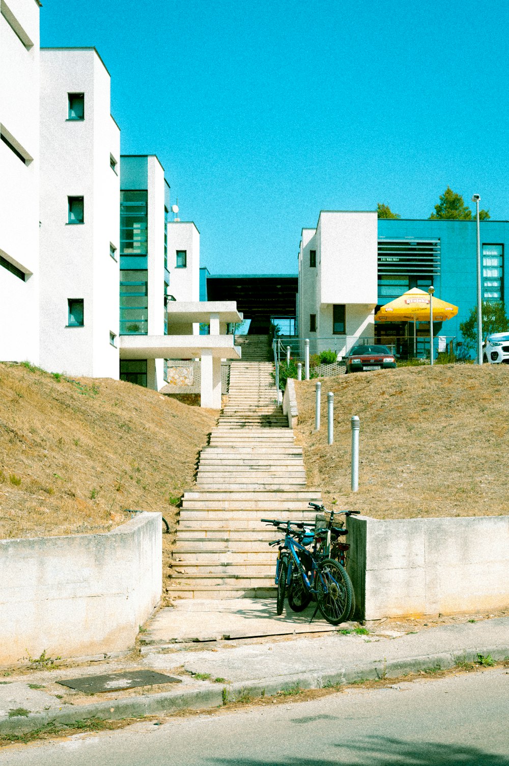 black bicycle parked beside white concrete building during daytime