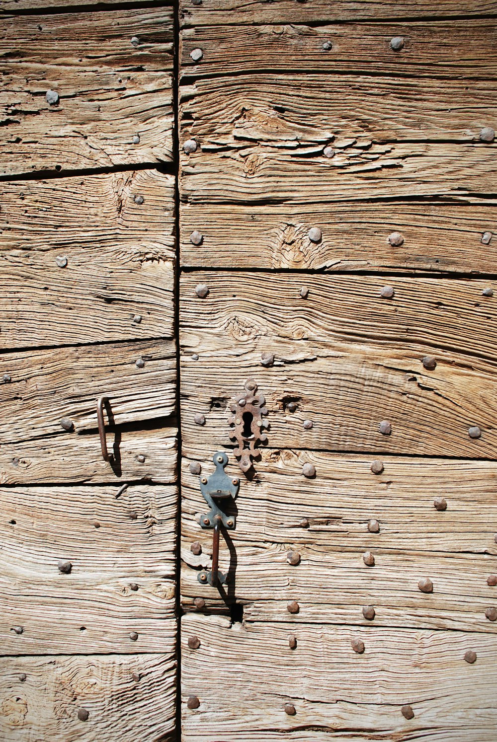 braune Holztür mit grauer Metallkette