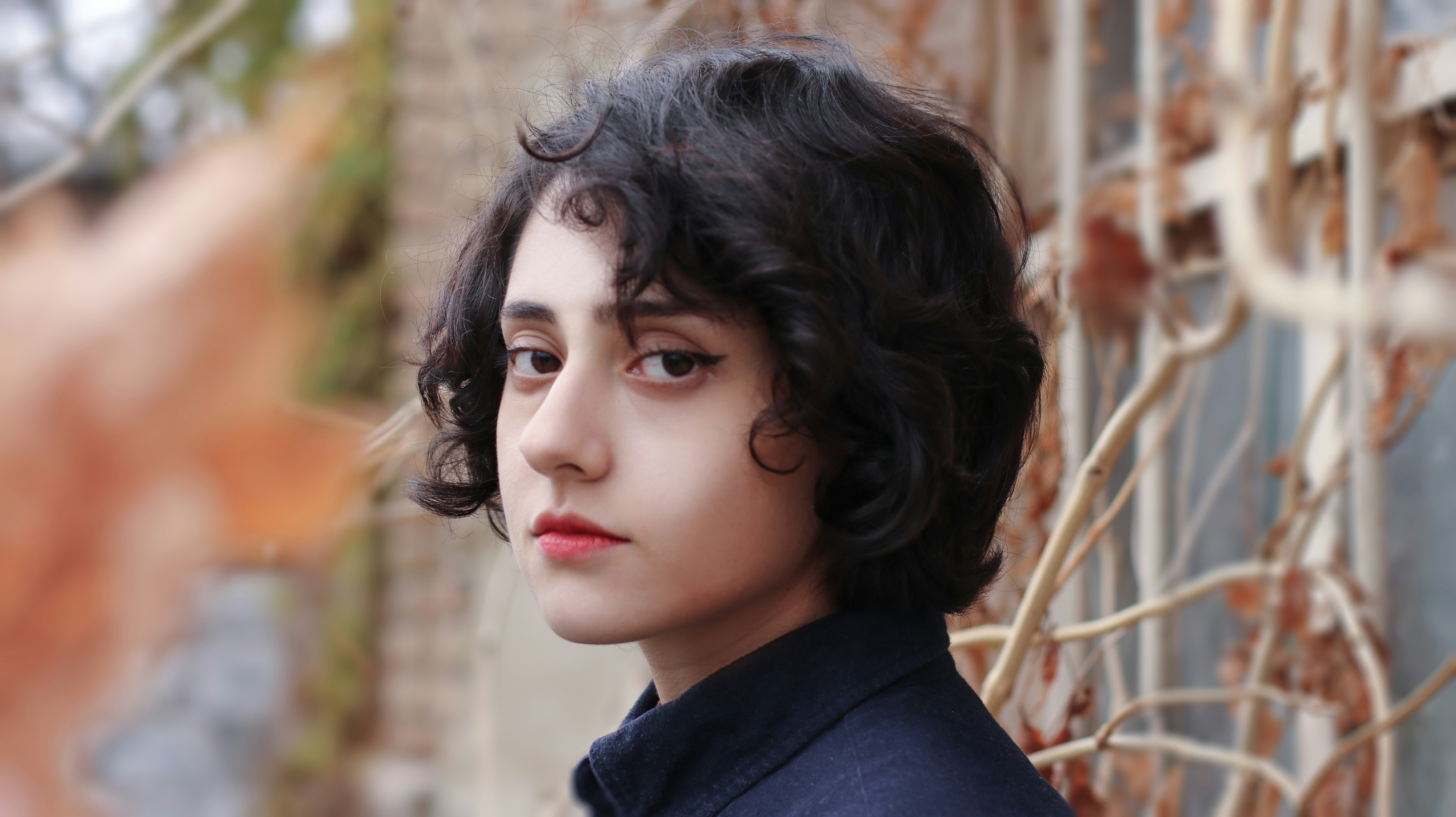 woman in black shirt standing near brown grass during daytime