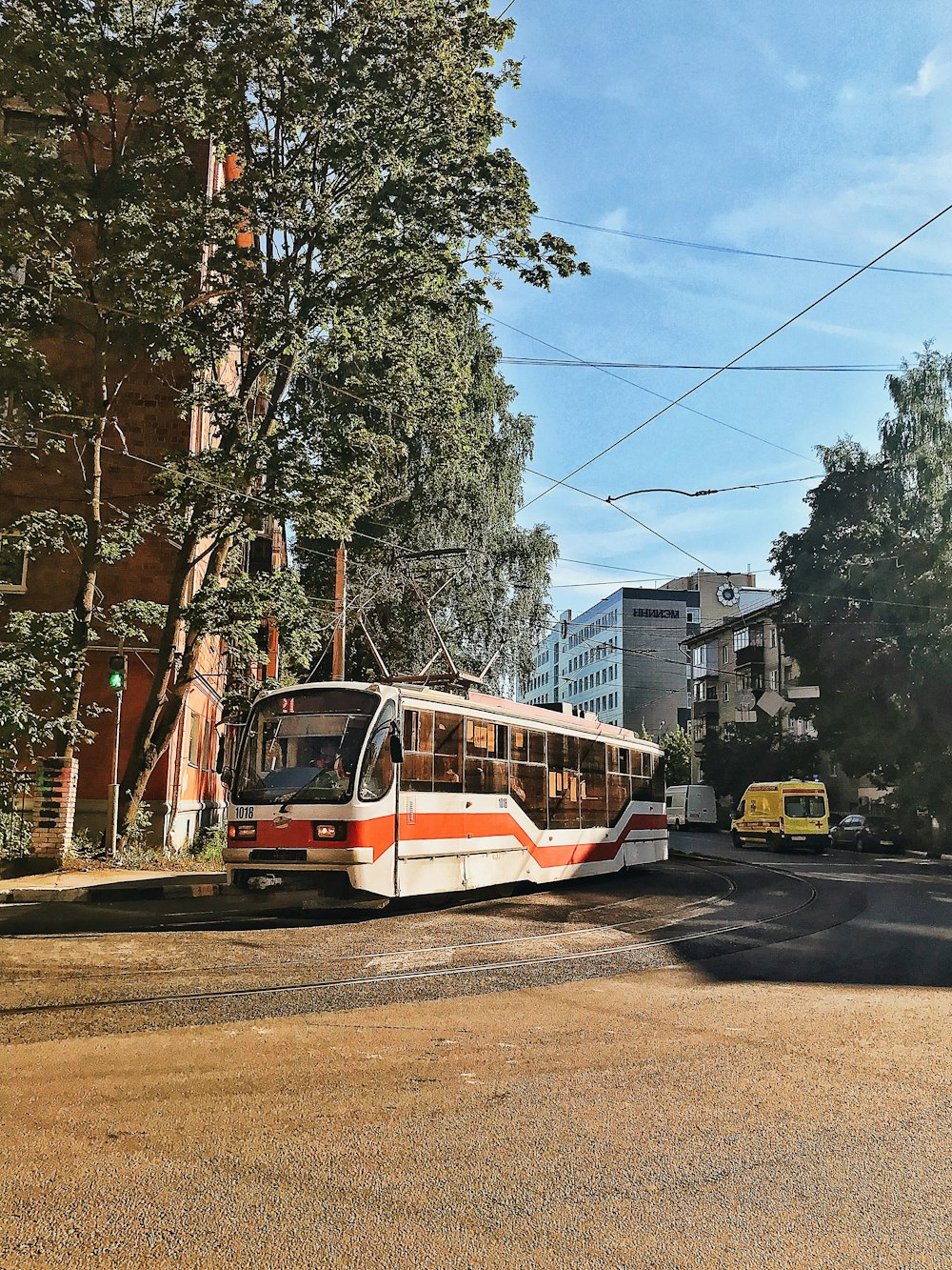 rot-weiße Straßenbahn tagsüber auf der Straße