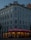 A multi-story building with intricate architectural details, featuring arched windows and decorative molding. The ground floor houses a restaurant named Floras Steakhouse, illuminated with neon red lights and warm string lights around the entrance.