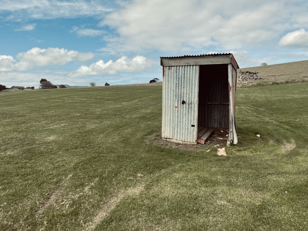 white wooden house on green grass field under blue sky during daytime