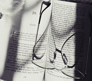 An open e-book showing a page of a thrilling mystery novel with a magnifying glass beside it.