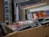 A collection of stacked CD cases inside a cardboard box, with visible album art and text on the covers. The CDs appear to be packed closely together, suggesting they are part of a larger collection.