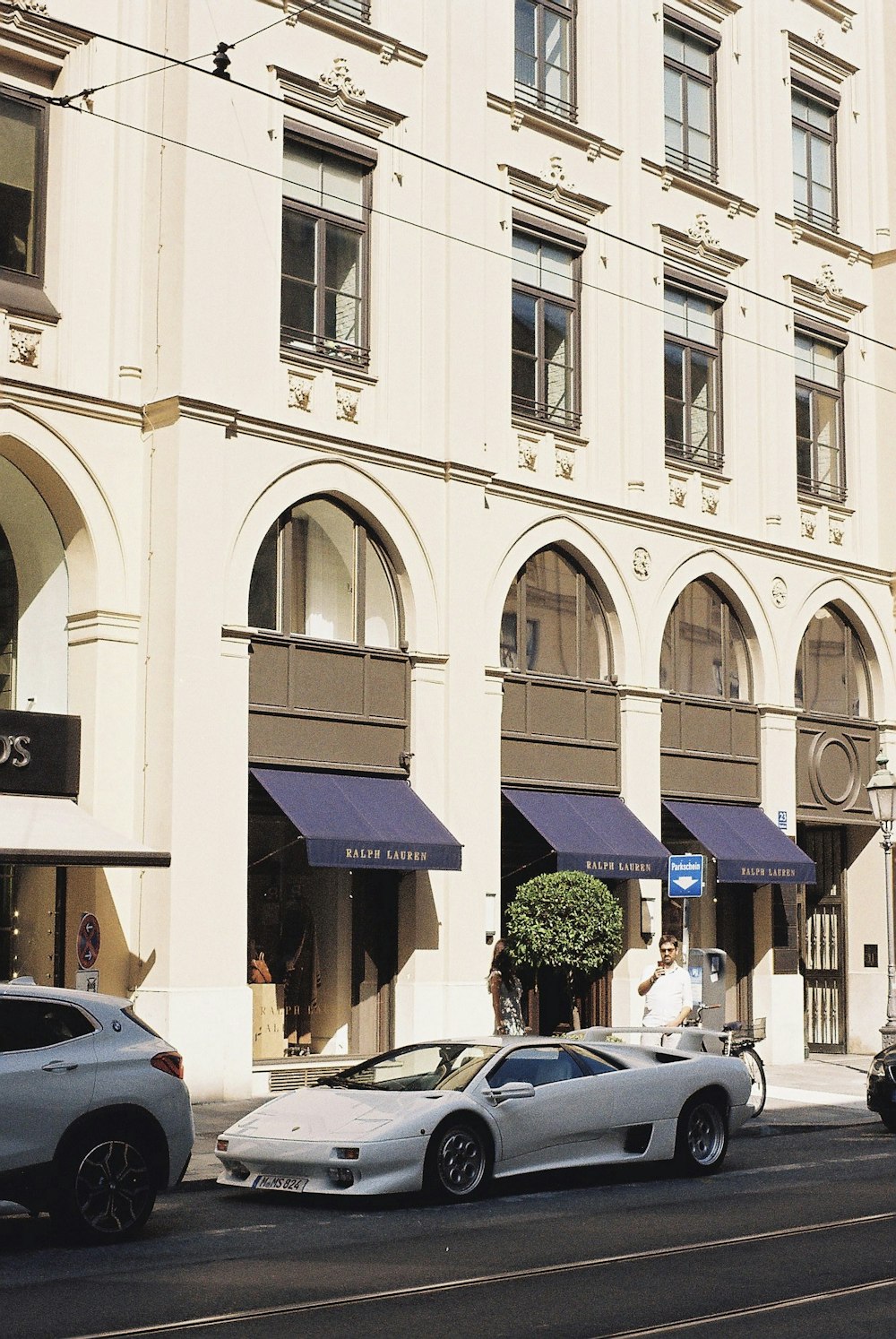 cars parked in front of white building during daytime