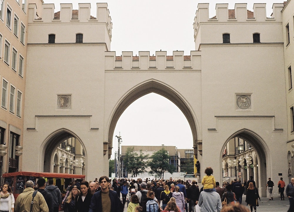 people standing near beige concrete building during daytime