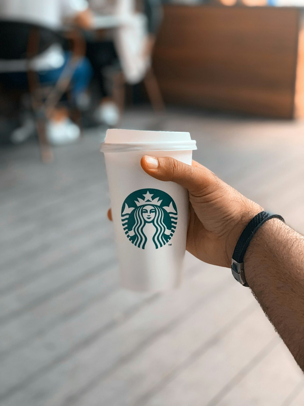 person holding white and blue starbucks cup
