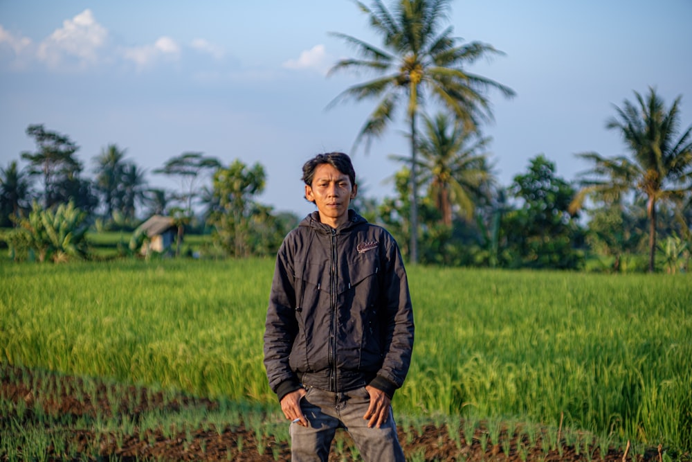 man in black jacket standing on green grass field during daytime