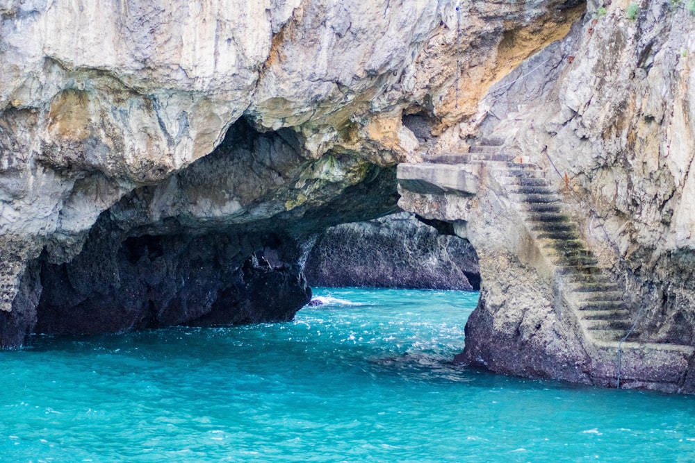 Montagna rocciosa marrone accanto al mare blu durante il giorno