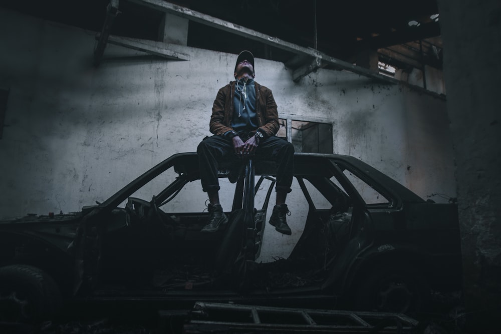 man in blue jacket standing beside black car