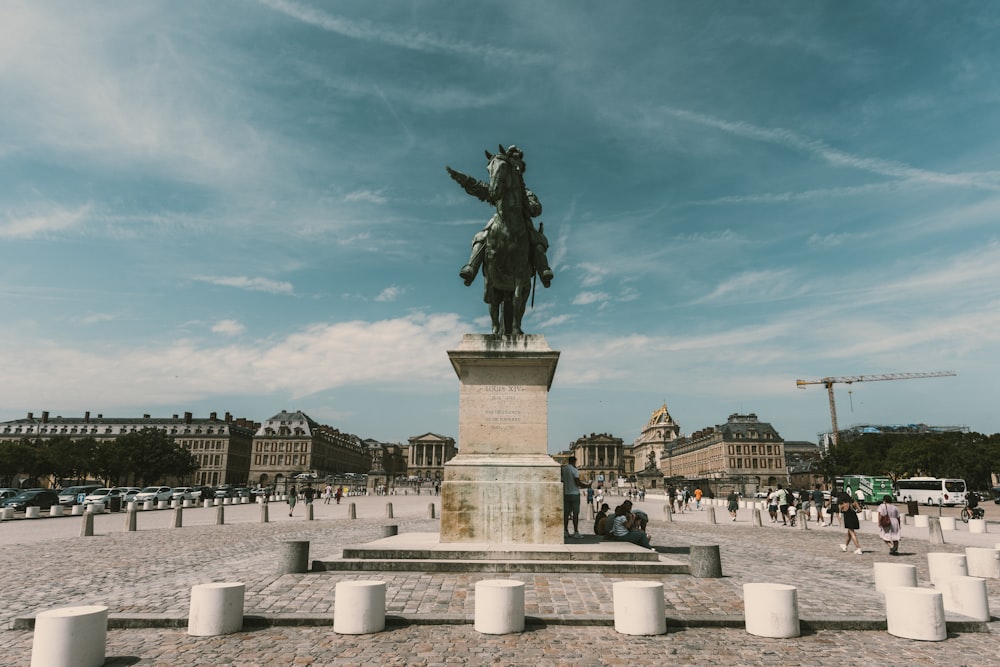 statue of man riding horse near building during daytime