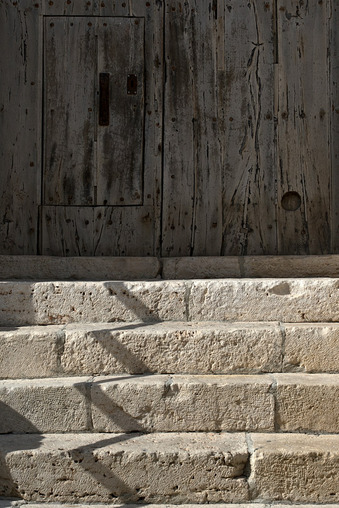 brown wooden door with white concrete wall