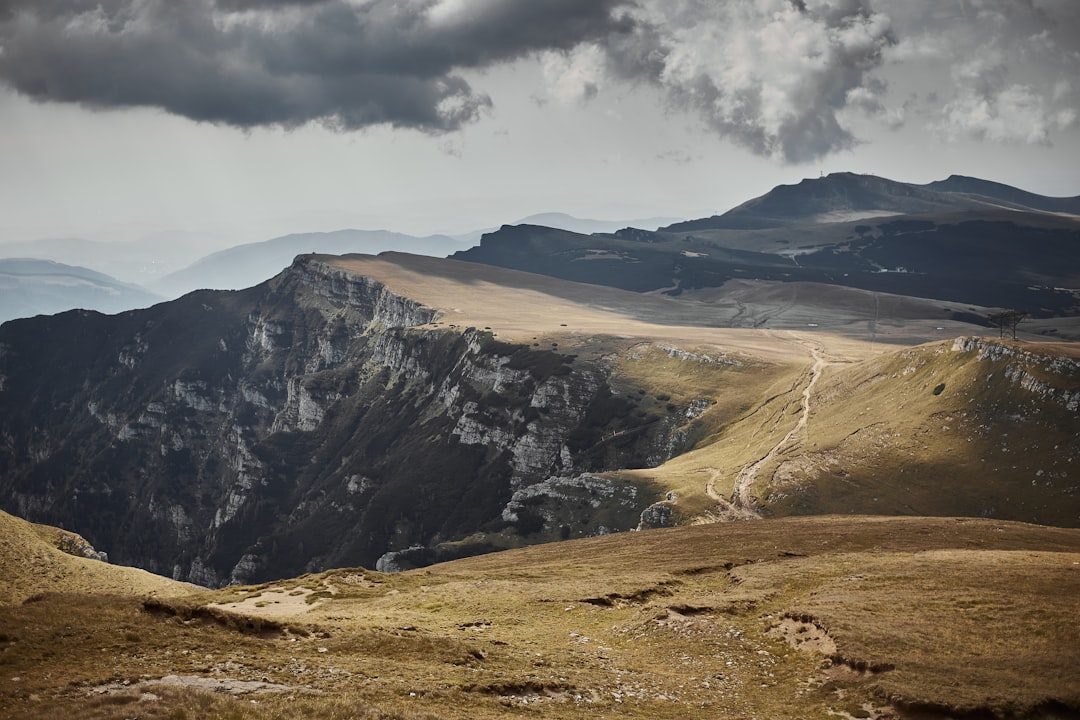 brown and black mountains under white clouds during daytime