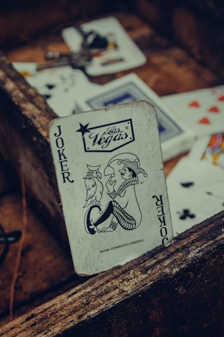 joker playing card on brown wooden table