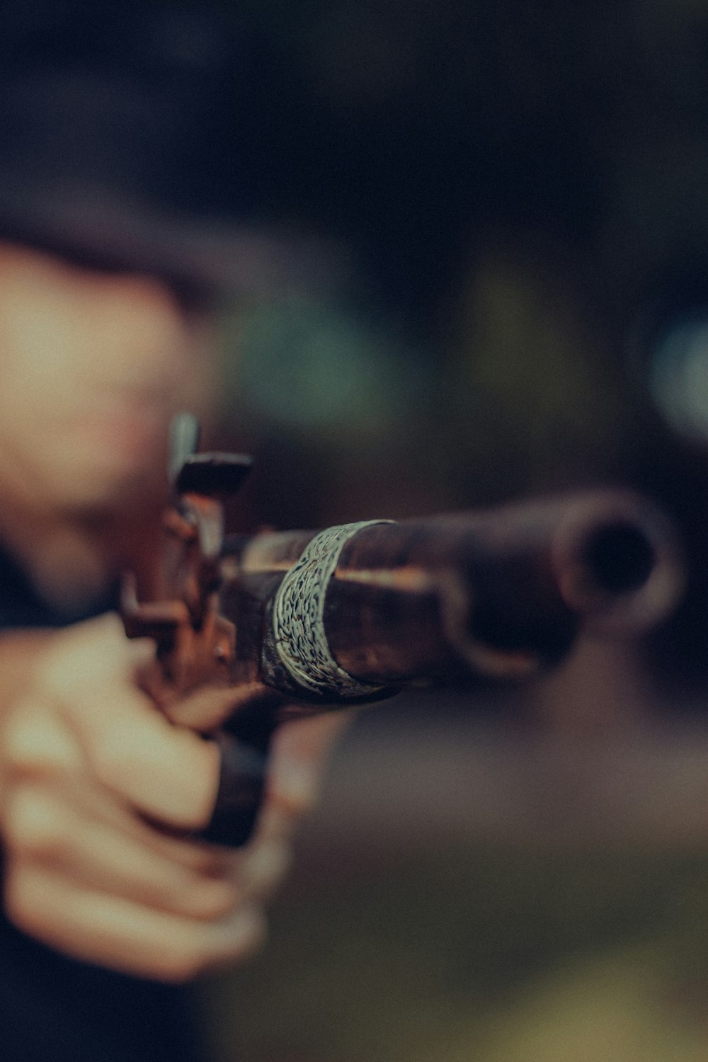 person holding black and brown rifle