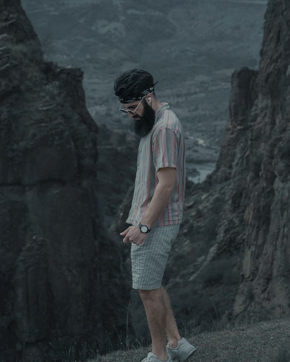 man in white and blue plaid button up t-shirt standing near cliff during daytime