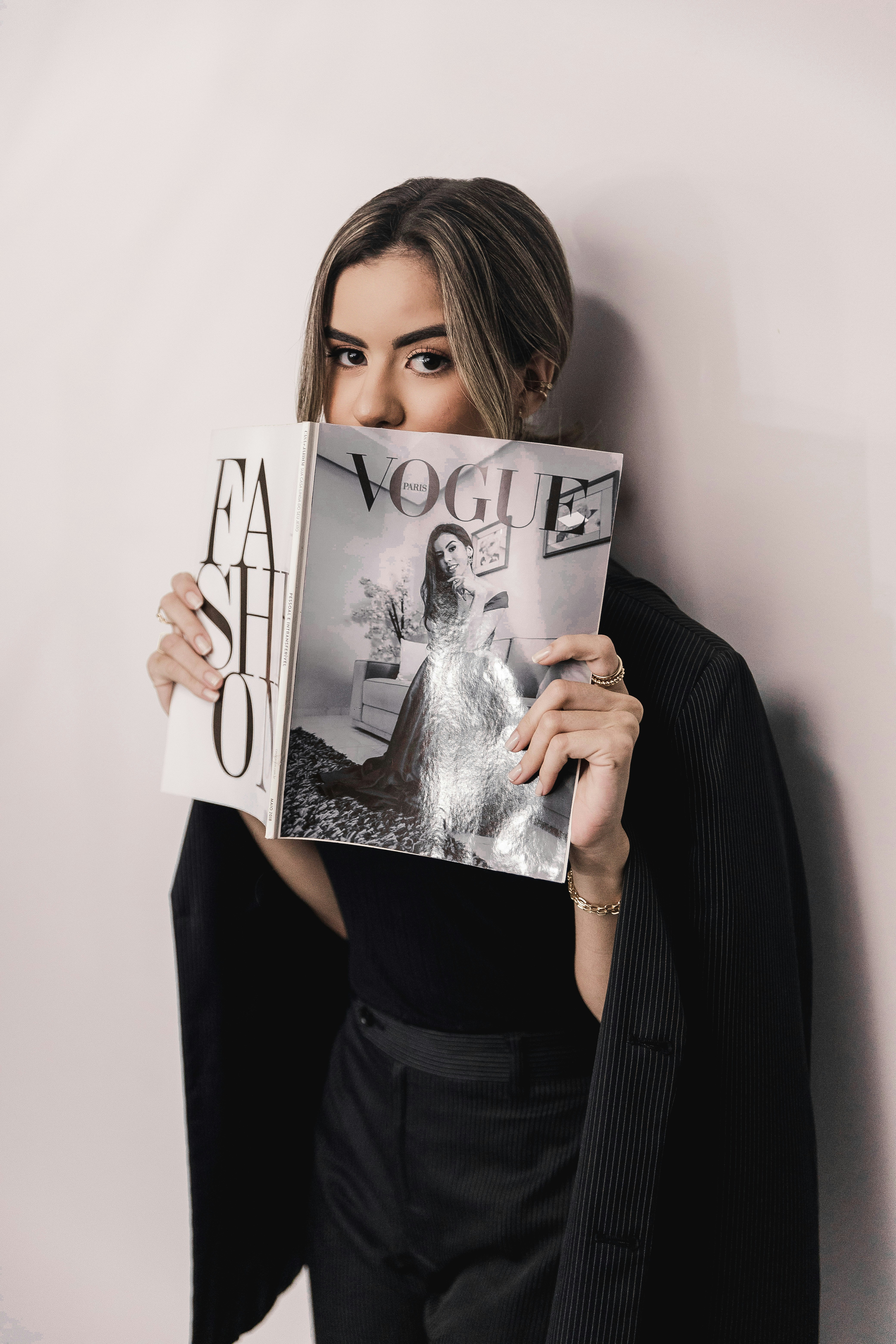 黒い長袖シャツを着た女性が白いプリンター用紙を持っている