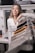 Smiling young woman trying on stylish clothes in a bright, modern room.