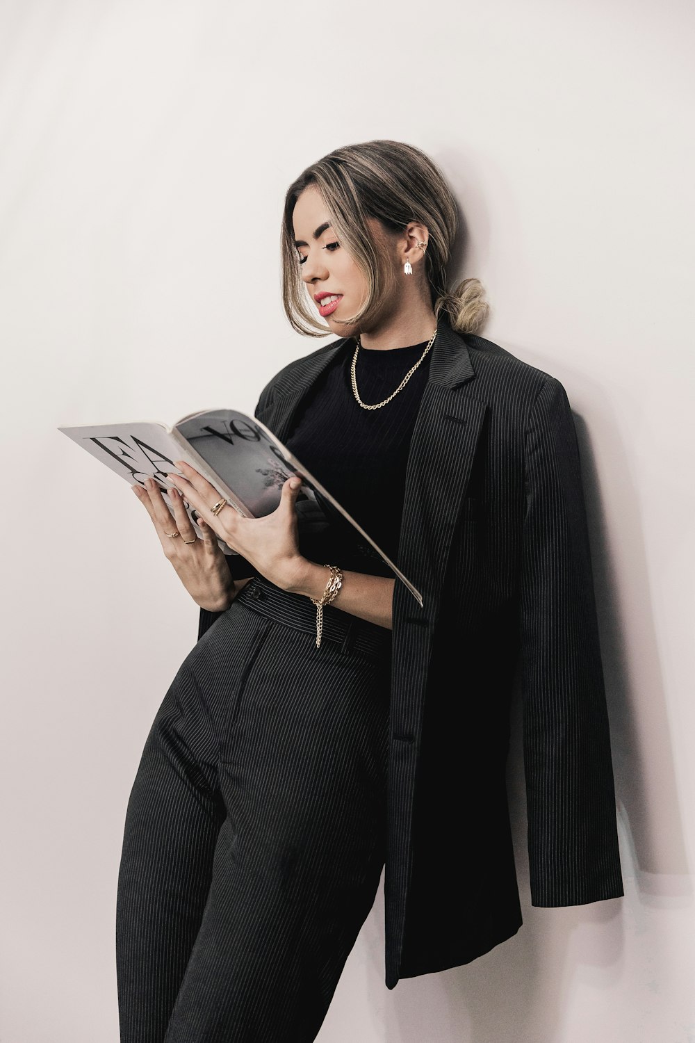 Mujer en blazer negro sosteniendo libro