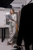 woman in white blazer and white pants standing beside white table