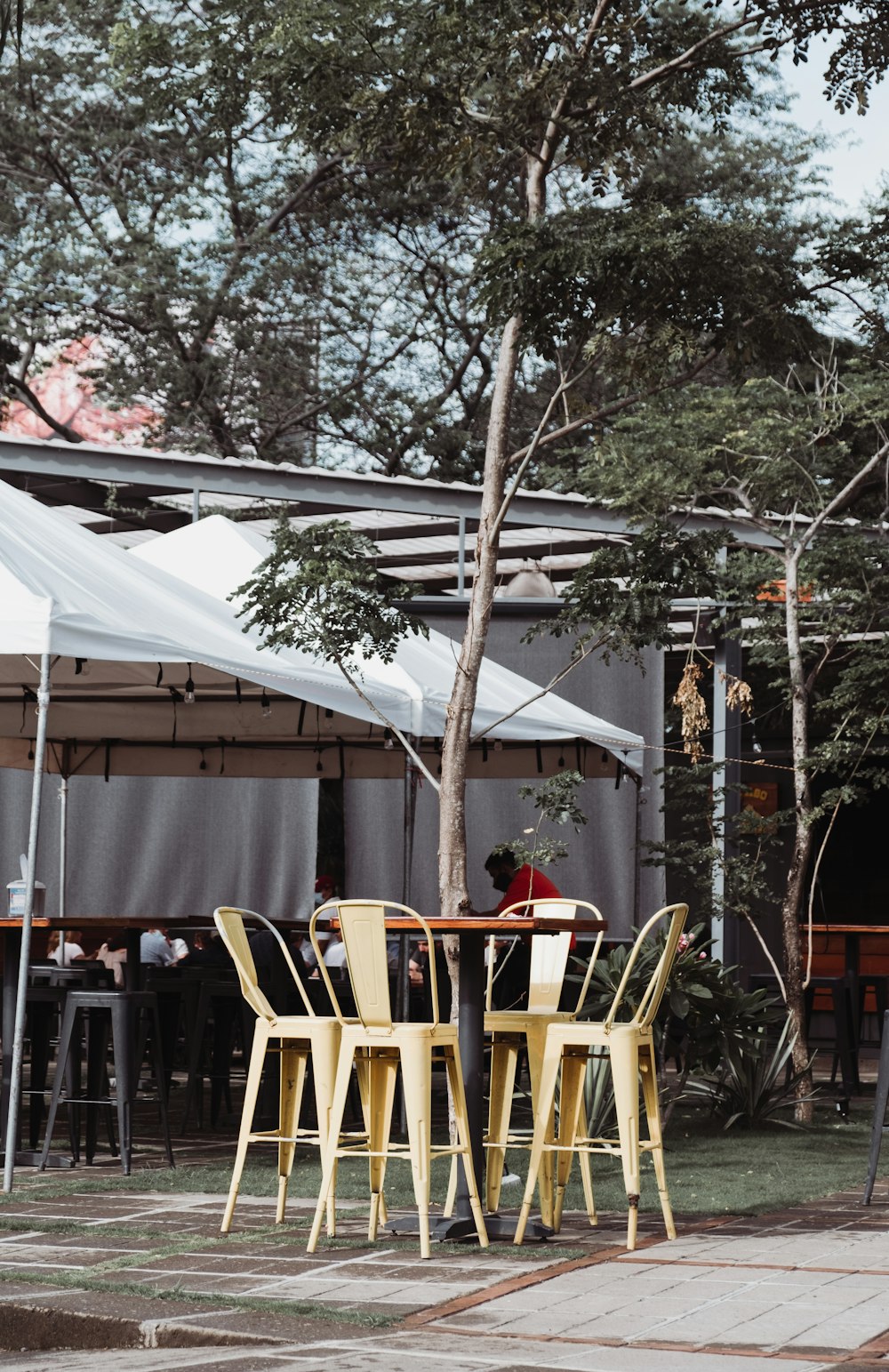 brown wooden chairs and table near white canopy tent