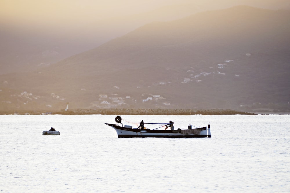 silhouette of 2 people riding on boat during daytime