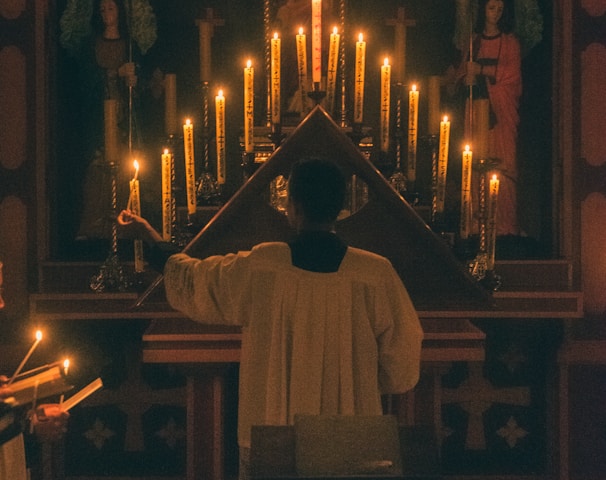 man in white thobe standing in front of church