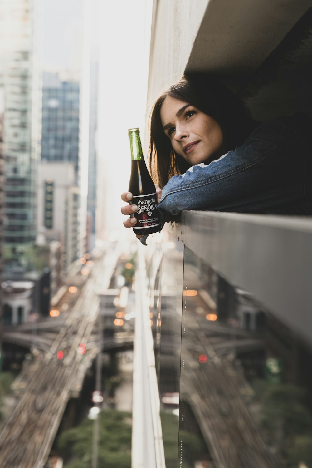 woman in blue denim jacket holding black ceramic mug