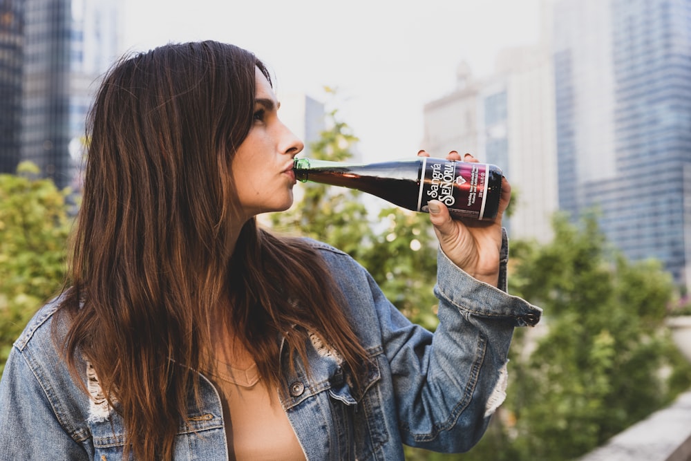 woman drinking coca cola bottle