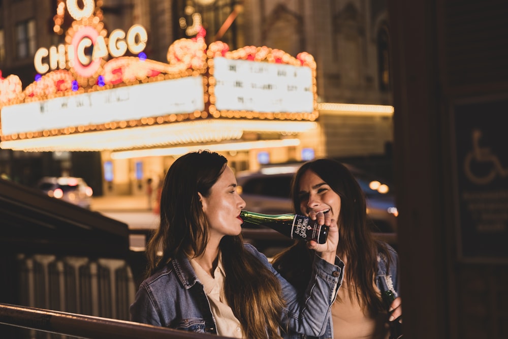 woman in black leather jacket drinking from bottle