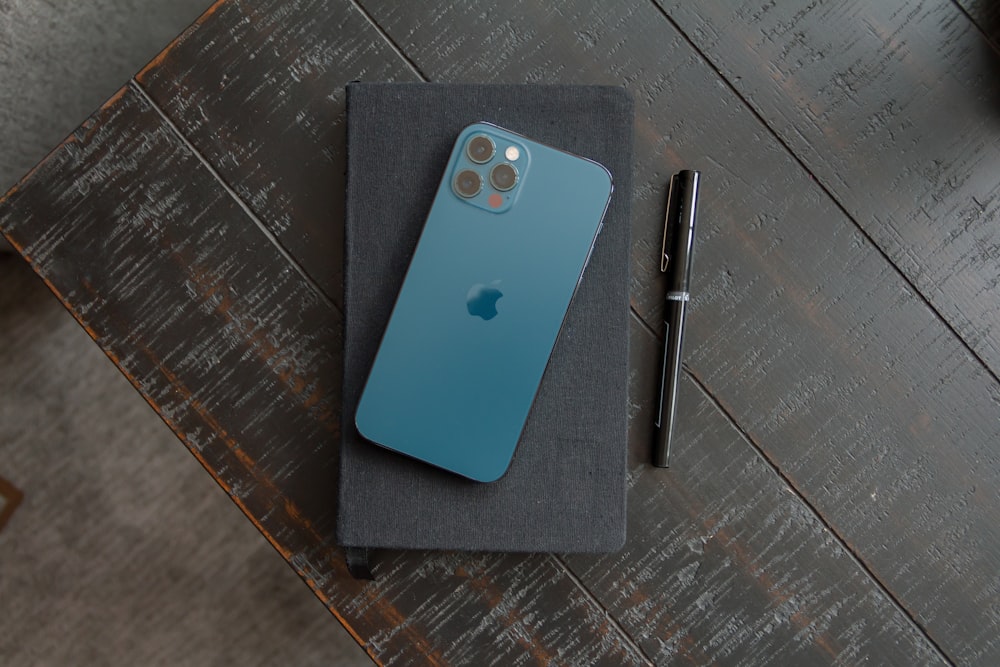 blue iphone case beside black pen