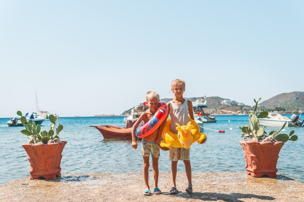 2 women standing on beach during daytime