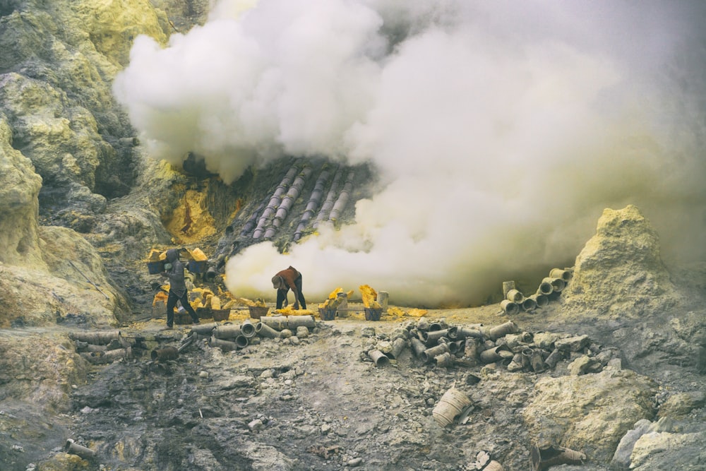 people sitting on rock near white smoke