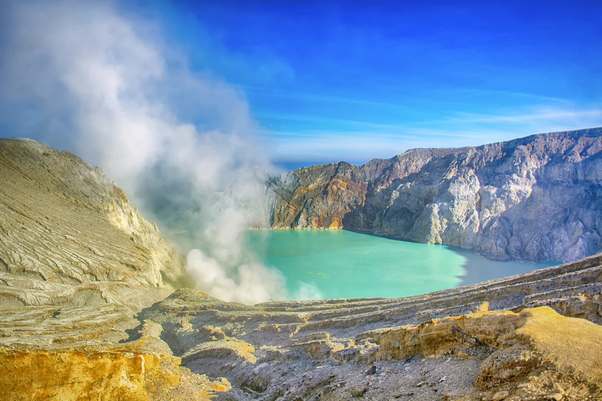 Blue flames of burning sulphur gas at the bottom of the Ijen crater before dawn
