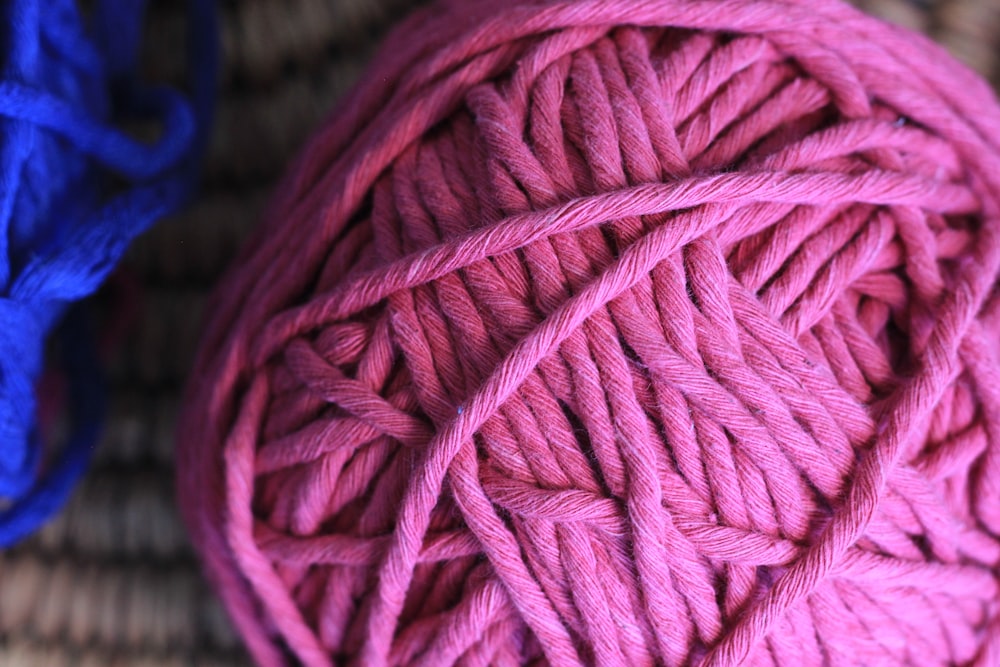 pink yarn on blue textile